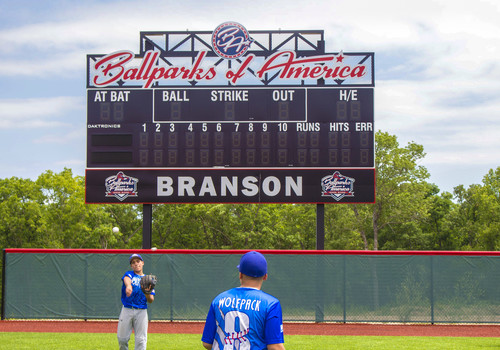 Branson Ballparks of America score board, with two boys tossing a baseball to each other, with blue uniforms.