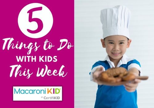 kid wearing a chef's hat holding out a plate of food