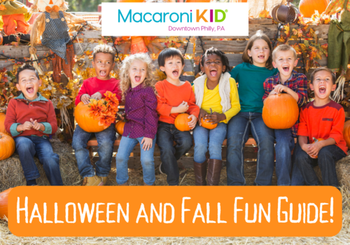 Children sitting on hay bales with pumpkins