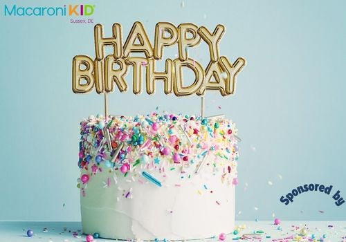 white round cake with pastel sprinkles and gold happy birthday candle