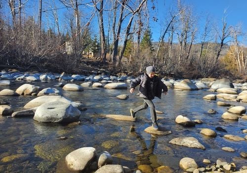 boy skipping rocks in river kids things do events happenings local reno sparks Spanish springs nevada deals discounts fun attractions ideas places to go outdoors hiking verdi trails park crystal peak