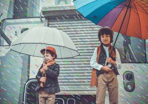 2 boys smiling in the rain