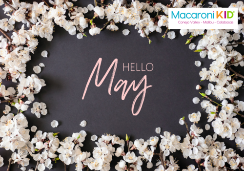 Hello May surrounded by light pink flowers
