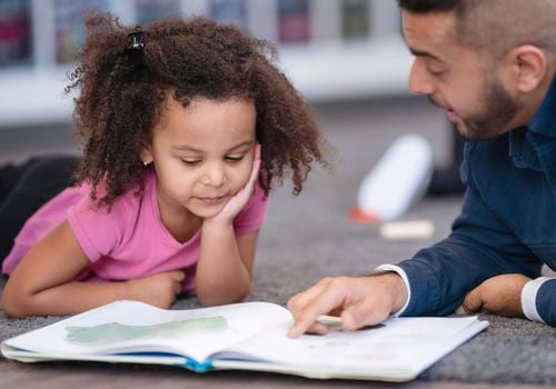 Student and teacher reading book