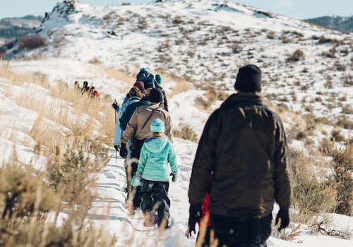 people of all ages hiking a snow-covered trail
