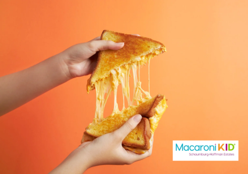 Image of persons hands splitting a cheesy grilled cheese