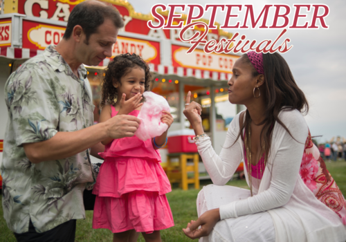 A family at a carnival, the child is eating cotton candy