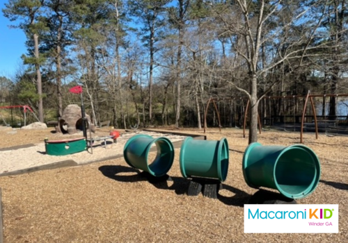 Playground with tunnels and sand with Macaroni KID Winder logo at bottom right