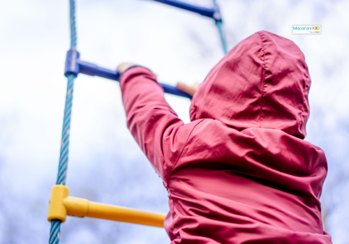 kid climbing on playground equipment.