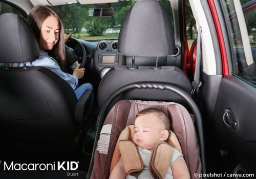 Mother looking back at baby in car seat