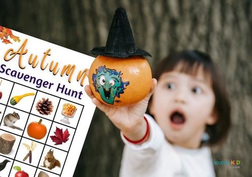 Little girl showing painted pumpkin