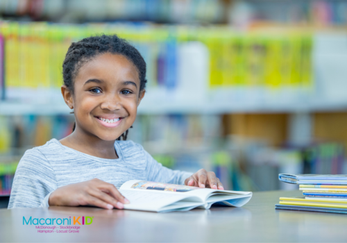 Girl of African American descent reading a book at a library