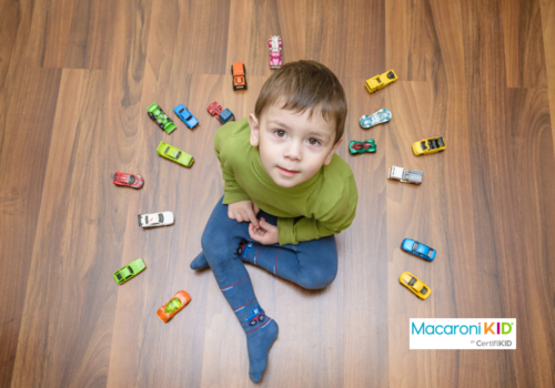 child playing with lots of toy cars indoor.
