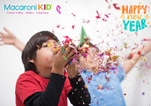 Happy New Year kids blowing confetti