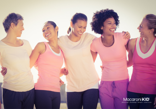 Five women embracing wearing pink workout gear