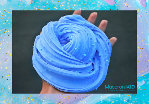 A hand holding up some puffy blue slime with foam balls