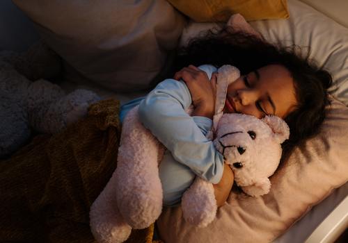 Child with bear in bed