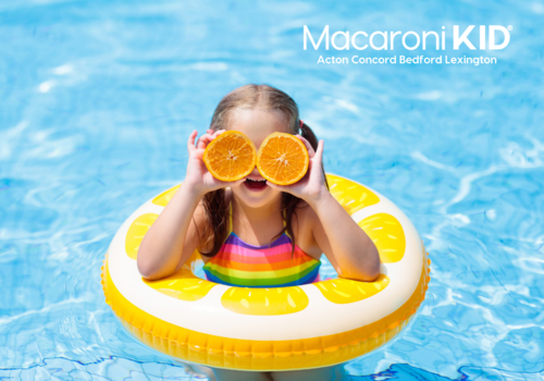 child in pool float with oranges over eyes