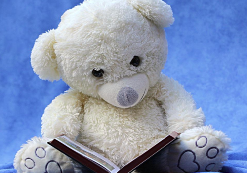 A stuffed bear reading a book