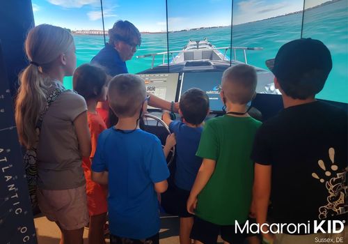7 children standing at ship navigation stimulator