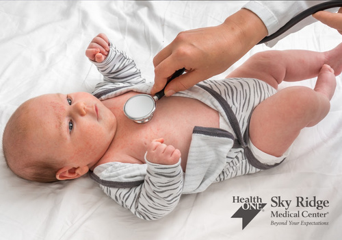 sick baby being checked with a stethoscope