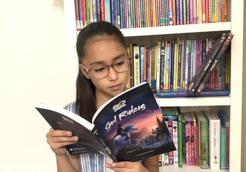 Little girl reading Soul Riders book