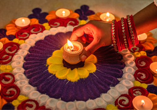 An image of Hindu sand art and candles to celebrate Diwali