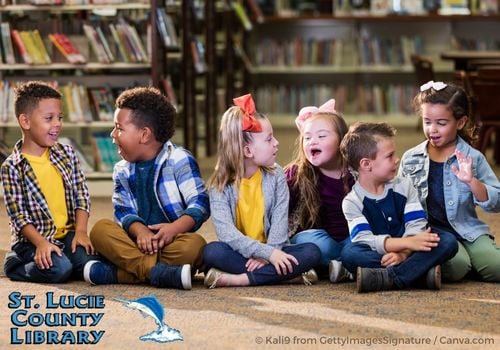 Children sitting on the floor talking to each other at the Library