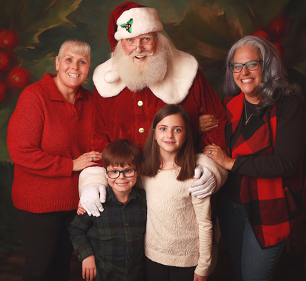 Shows the publisher, Emily with her wife, 2 young children and Santa Claus