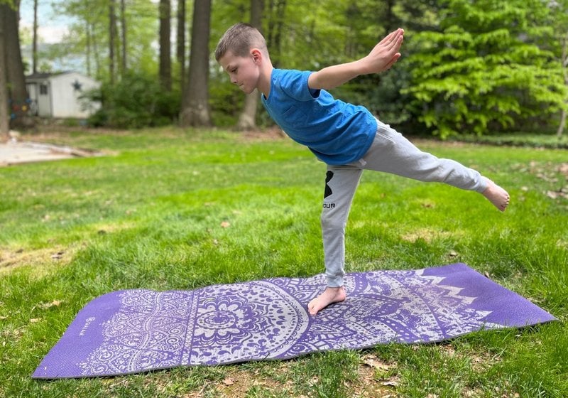 Boy doing yoga outdoors.