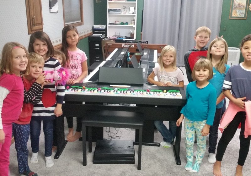 Group of kids by piano