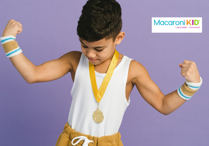 Child with medal on flexing muscles