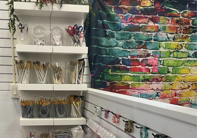 Shop display of art supplies with a colorfully painted wall