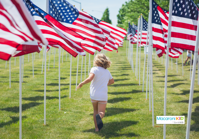 Memorial Day -- child running through flags