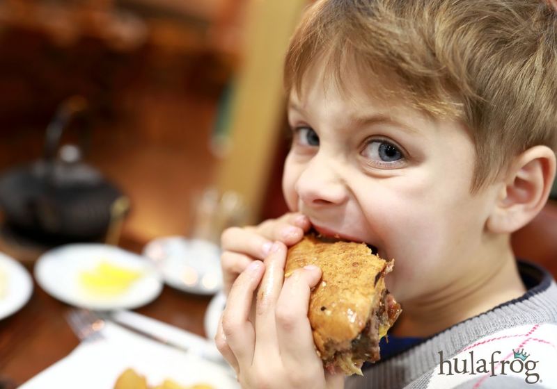 kid eating burger in restaurant