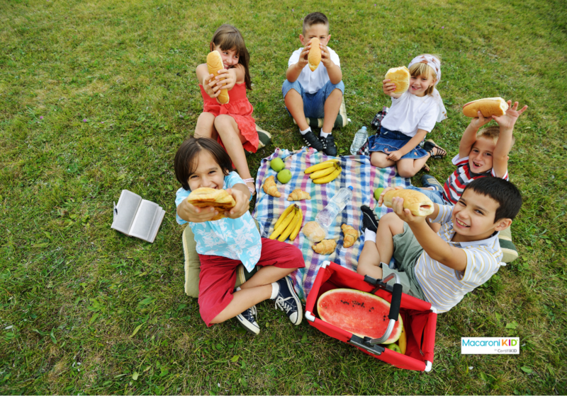 Kids at picnic with book on grass