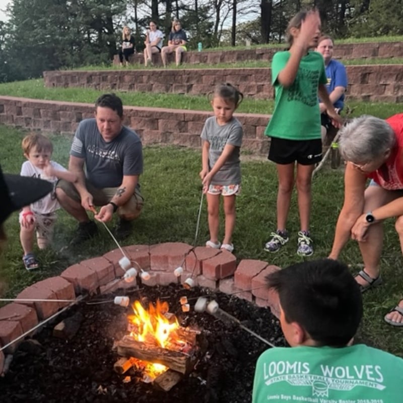 Kids making s'mores around camp fire