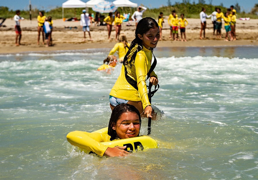Students at Junior Lifeguards camp doing water safety drills
