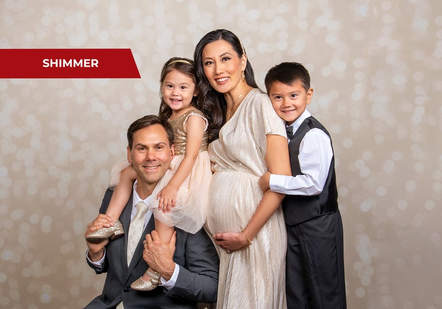 Family smiling with twinkling lights in the background, holiday photo session at JCPenney Portraits