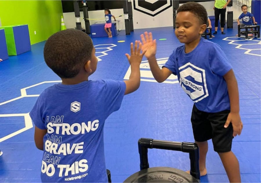 two children high five in a kidstrong class