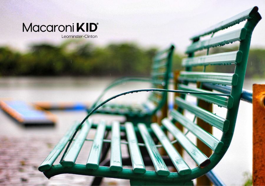 Image shows an empty park bench at a lake.