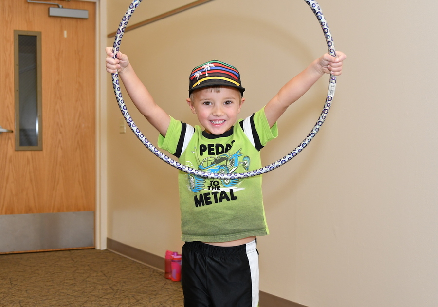 smiling young boy holding a hula hoop