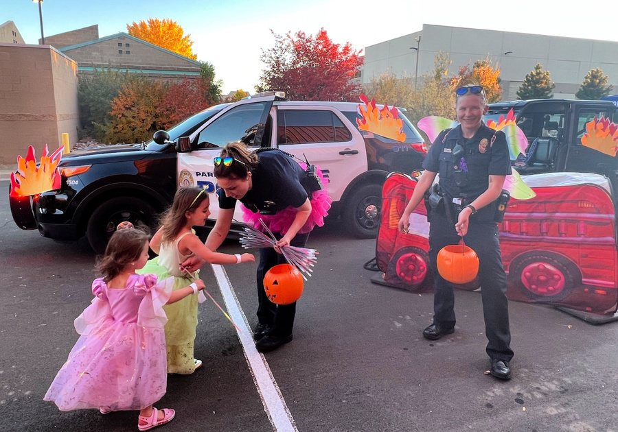 Parker Police Department officers handing out treats to children in cHalloween ostumes