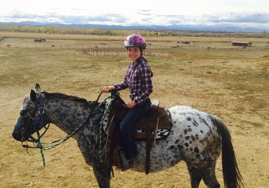 smiling child on horseback at Big Horn Stables