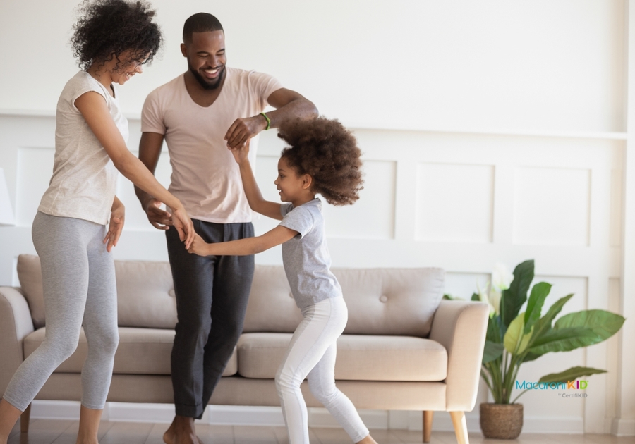 Happy family with kid dancing at home