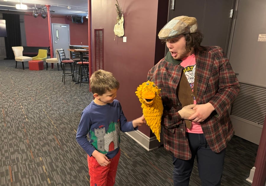 A young boy excitedly meets the Golden Goose puppet after the Gamut Theatre performance, chatting with one of the talented cast members.