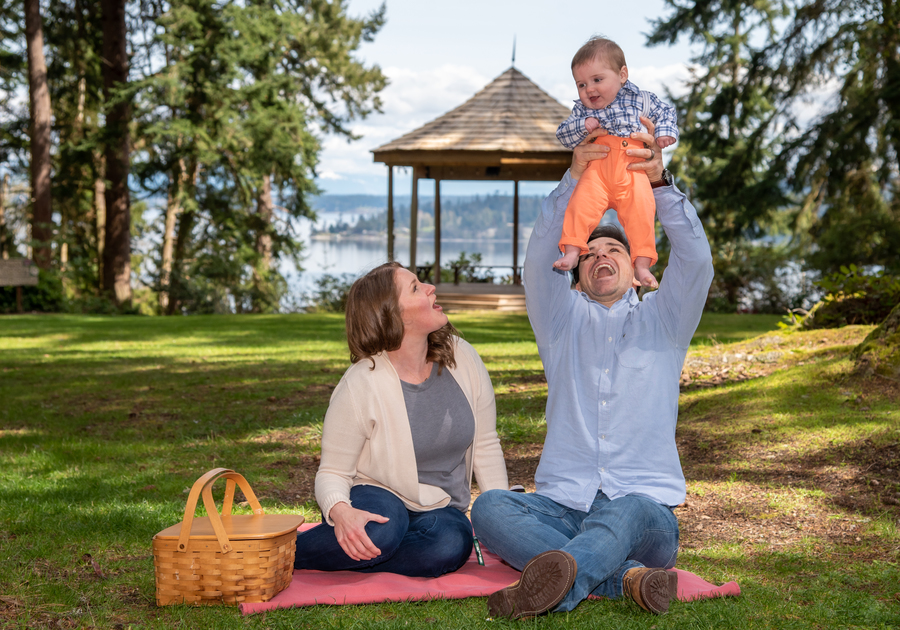 Mother's Day at Meerkerk Gardens - young couple smiles holding their infant with a gazebo in the back