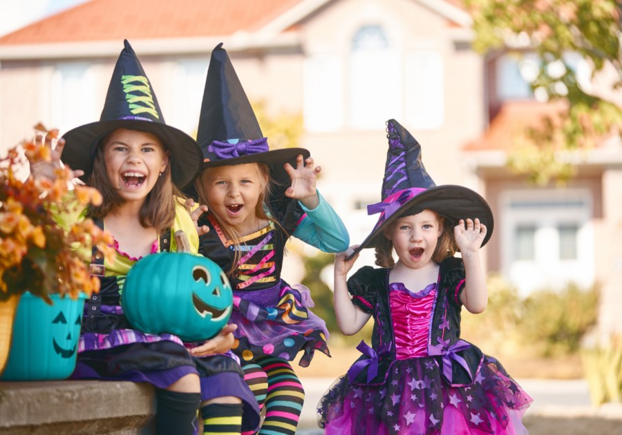 Kids in halloween costumes with teal pumpkins