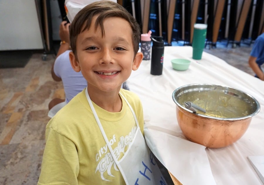 photo of young camper seated with mixing bowl