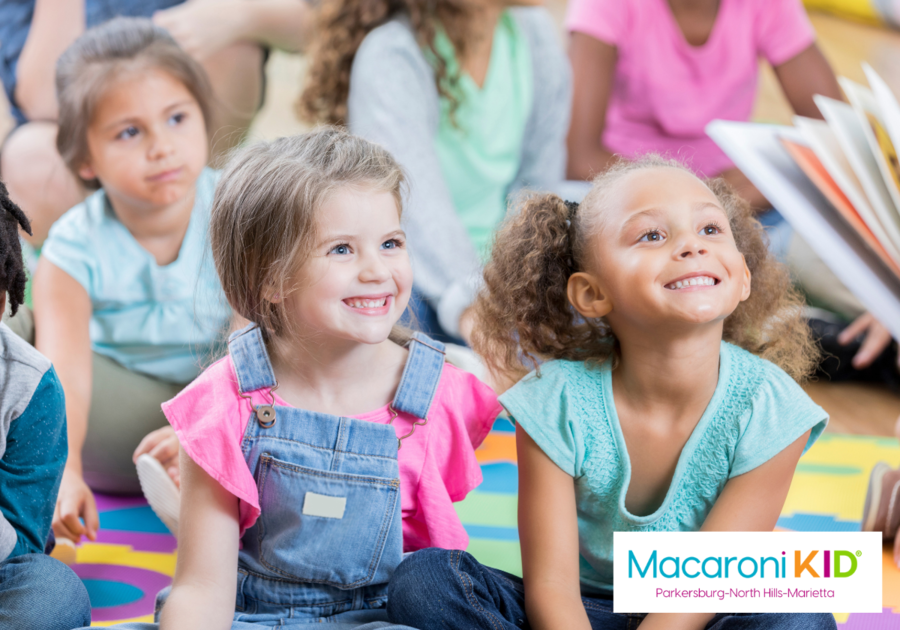 Two elementary aged girls sit on the floor during a story time